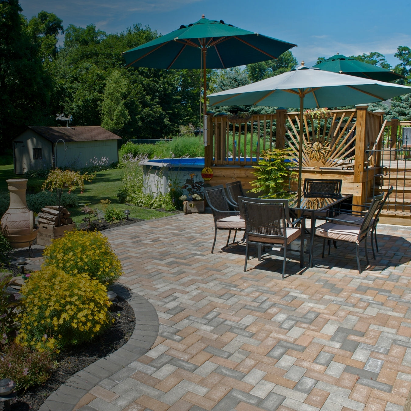 Sunny backyard patio with paver stones and green umbrellas