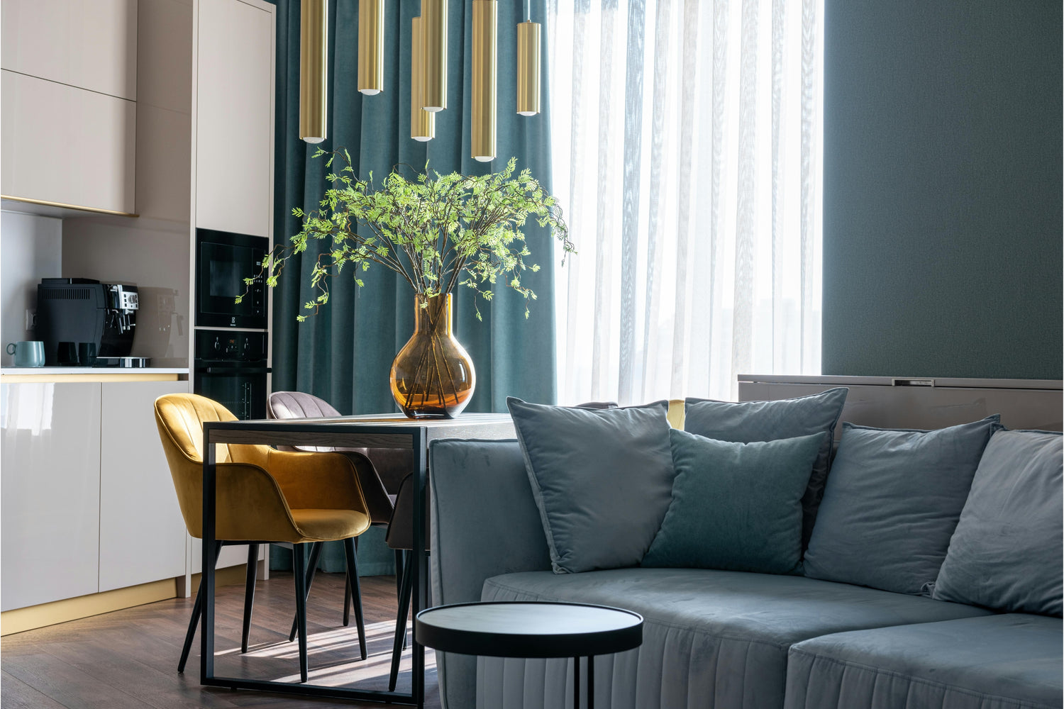 Modern living room with a gray sofa, dining table, and chairs.